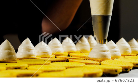Chef is making a batch of macarons, close-up. 67607823