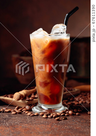 Ice coffee with cream being poured into it showing Ice coffee with cream being poured into it showing 67611390