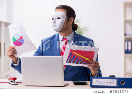 Male employee with mask in hipocrisy concept 67611575