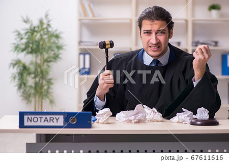 Young male judge working in courthouse 67611616