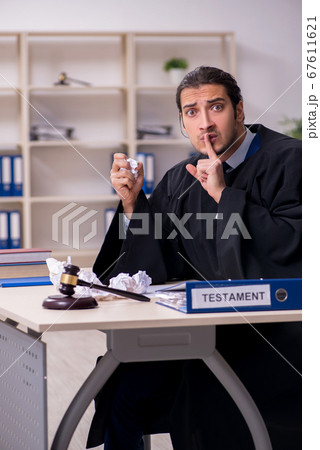 Young male judge working in courthouse Young male judge working in courthouse 67611621