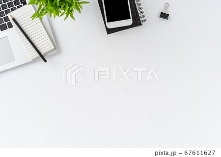 Overhead shot of modern office desktop with laptop and business accessories on white background with copyspace. Flat lay 67611627