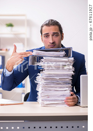 Young male employee unhappy with excessive work 67611927