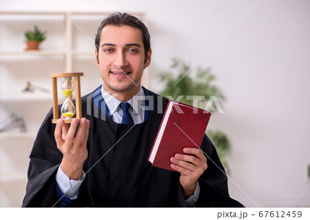 Young male judge in time management concept 67612459