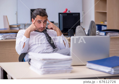 Young male employee unhappy with excessive work Young male employee unhappy with excessive work 67612726