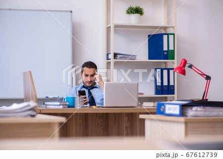 Young male businessman employee working in the office Young male businessman employee working in the office 67612739