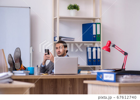 Young male businessman employee working in the office Young male businessman employee working in the office 67612740