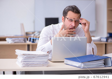 Young male employee unhappy with excessive work 67612941
