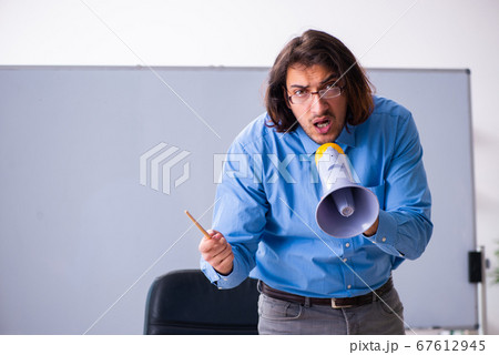 Young male teacher in the classroom 67612945