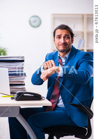 Young male employee unhappy with excessive work 67613013