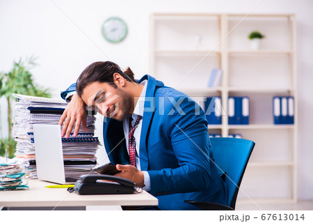 Young male employee unhappy with excessive work Young male employee unhappy with excessive work 67613014