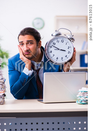 Young male employee unhappy with excessive work Young male employee unhappy with excessive work 67613015