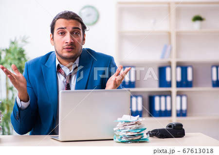 Young male employee unhappy with excessive work 67613018