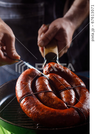 Homemade sausage cooked on a grill, with tomatoes. 67613071
