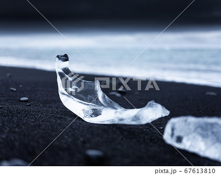 Diamond beach, Iceland. Ice on black sand on the beach. Ocean bay and icebergs. 67613810