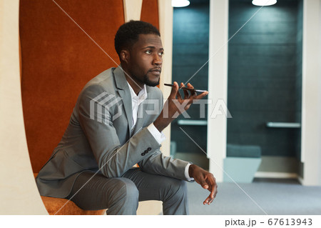 African-American Businessman Recording Voice Message via Smartphone African-American Businessman Recording Voice Message via Smartphone 67613943