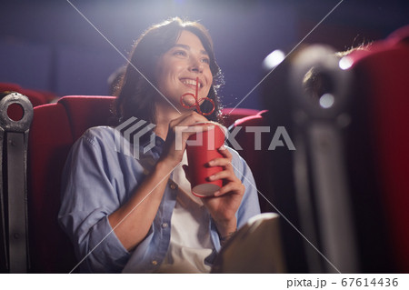 Smiling Woman Watching Movie in Cinema 67614436