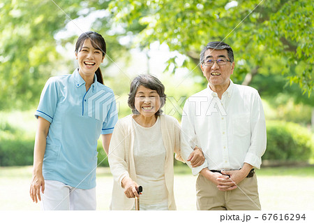 公園を歩くシニアのカップルと介護士 公園を歩くシニアのカップルと介護士 67616294