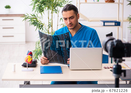 Young male doctor recording video for his blog 67621226