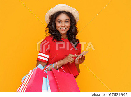Cheerful female shopaholic using smartphone 67621995