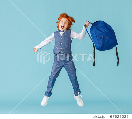 Excited schoolboy jumping with backpack. 67622025