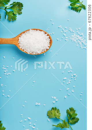 Sea salt in a wooden spoon on Large salt crystals 67622306