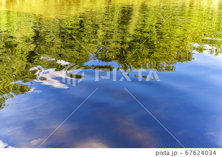Wavy water surface of the river with reflection of 67624034