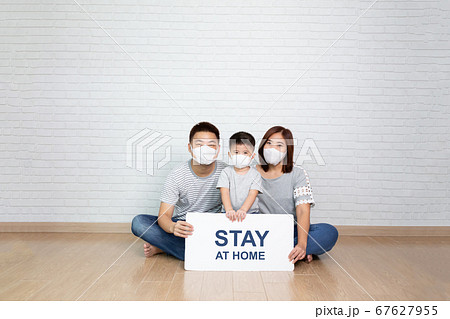 Asian family wearing protective medical mask holding white paper with stay at home. Asian family wearing protective medical mask holding white paper with stay at home. 67627955