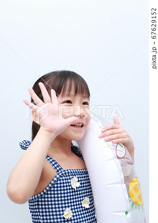 真夏に水着を着て浮き輪で遊ぶ女の子 67629152