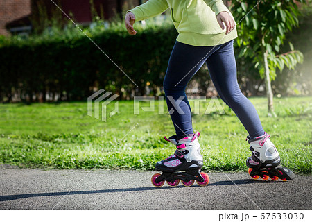 Teenage girl is skating on roller blades in the 67633030