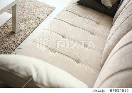 Comfortable light coloured sofa in cozy apartment 67634616