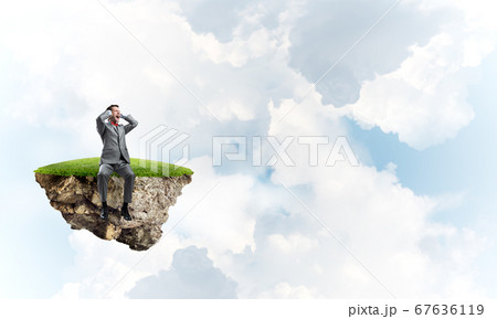 Young man on floating island do not want to hear anything 67636119