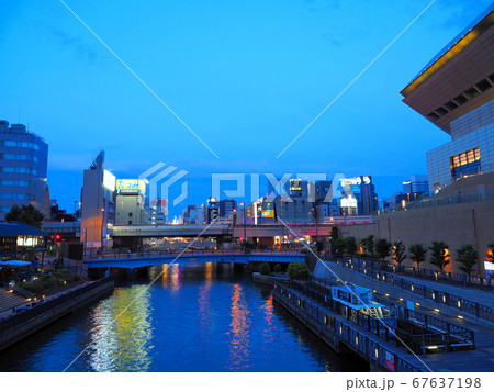 夕暮れの大阪ミナミ 道頓堀川にかかる深里橋と湊町リバープレイス 67637198