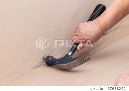 Closeup hand with nail and hammer at wall. Closeup hand with nail and hammer at wall. 67638292
