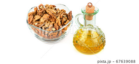 Walnuts and walnut oil in a bottle isolated on Walnuts and walnut oil in a bottle isolated on 67639088