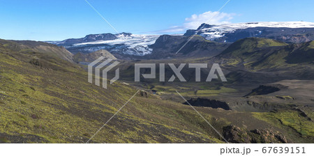 Panoramic landscape with blue Markarfljot river canyon, green hills and eyjafjallajokull volcano glacier. Laugavegur hiking trail. Fjallabak Nature Reserve, Iceland. Summer blue sky 67639151