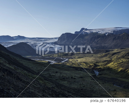 Icelandic landscape with eyjafjallajokull glacier tongue, Markarfljot river and green hills. Fjallabak Nature Reserve, Iceland. Summer blue sky Icelandic landscape with eyjafjallajokull glacier tongue, Markarfljot river and green hills. Fjallabak Nature Reserve, Iceland. Summer blue sky 67640196