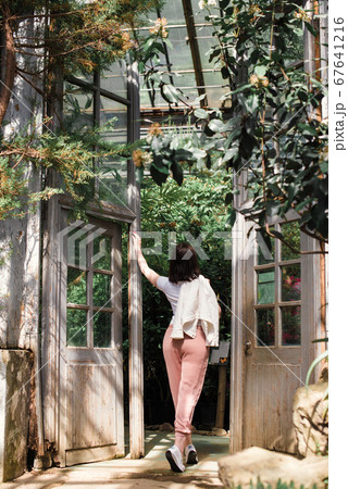 A beautiful young girl walks through an old 67641216