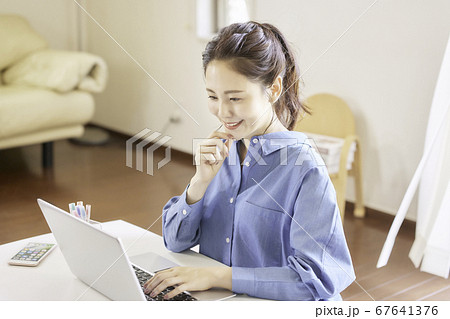 リビングでパソコンを使用する若い女性 67641376
