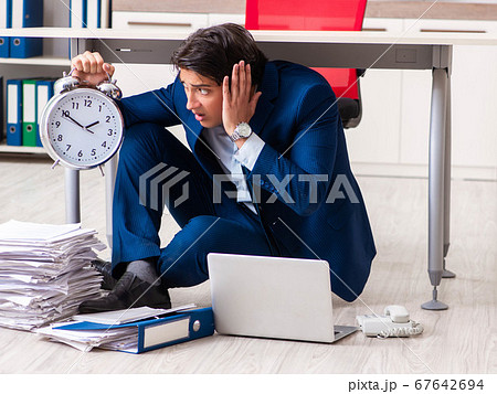 Tired exhausted businessman working overtime in office Tired exhausted businessman working overtime in office 67642694