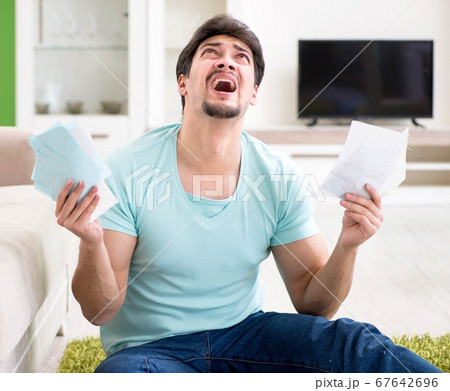 Young man struggling with personal finance and bills Young man struggling with personal finance and bills 67642696