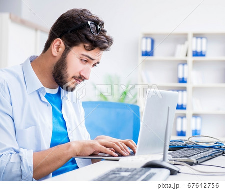 IT technician looking at IT equipment 67642756