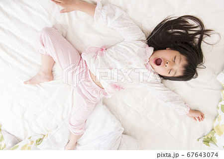 ベッドで眠る女の子 67643074