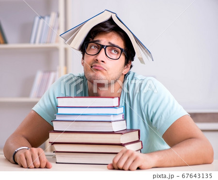 Young handsome student preparing for school exams Young handsome student preparing for school exams 67643135
