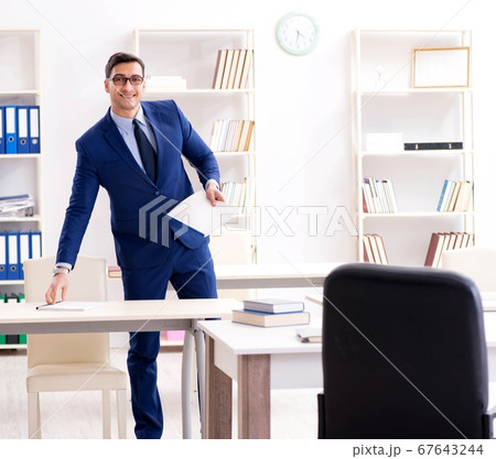Young handsome businessman employee working in office at desk 67643244