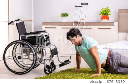 Young handsome disabled man recovering at home Young handsome disabled man recovering at home 67643330