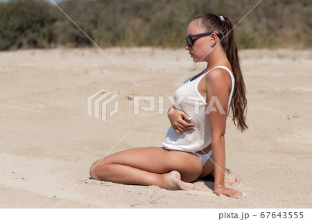 Provocative lady in top and panties on beach 67643555