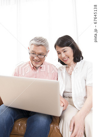 ノートパソコンを見るシニア夫婦 67645138