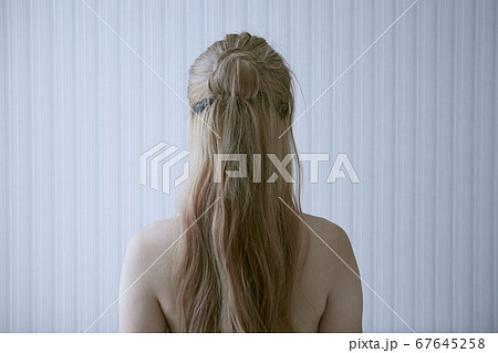 爽やかな朝と部屋の壁紙の見える女性の後ろ姿の写真素材