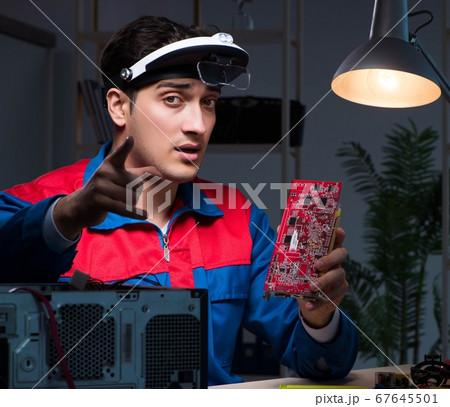 Computer specialist repairing PC late at night 67645501